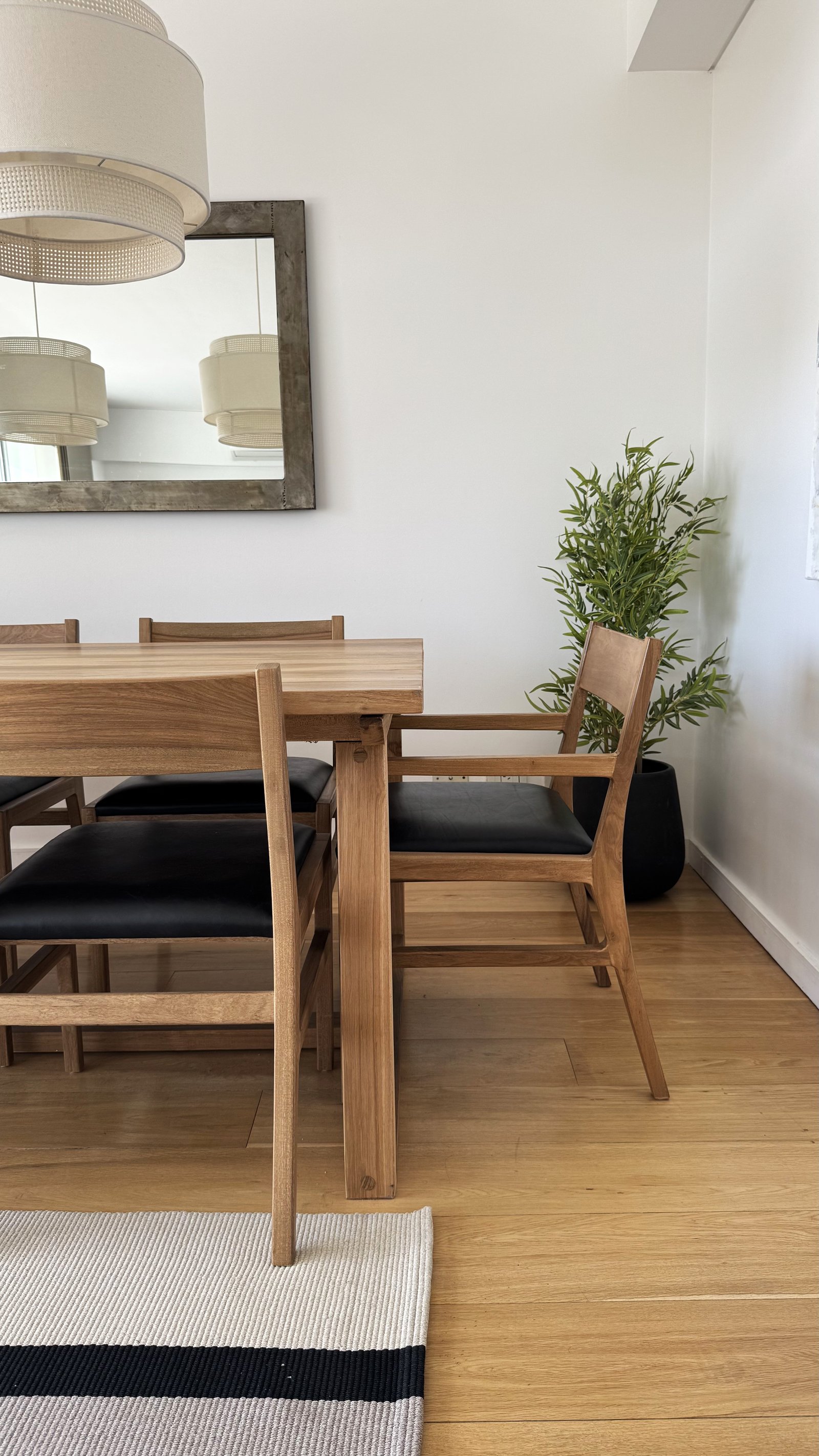 Comedor escandinavo con mesa de madera y sillas de cuero negro — proyecto Rosales Park Tower HJ, por Hermann Arquitectos, en Cmte. Leonardo Rosales 2793 B1636DRA